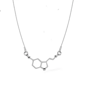 Silverhalsband molekylen för Serotonin: Ett halsband i silver med ett hänge utformat som serotoninets kemiska struktur, presenterat på en enkel kedja mot vit bakgrund.