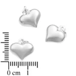 Tre Silverberlock Kupat Hjärta berlocker, var och en hjärtformad och silverglänsande med små öglor på toppen, visas nära en linjal för skala. Varje berlock är ca 13 mm bred och har vit bakgrund.