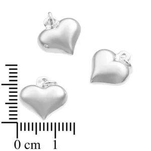 Tre Silverberlock Kupat Hjärta berlocker, var och en hjärtformad och silverglänsande med små öglor på toppen, visas nära en linjal för skala. Varje berlock är ca 13 mm bred och har vit bakgrund.