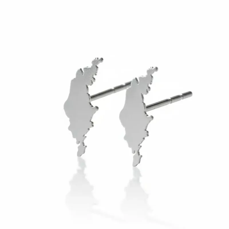 Ett par Örhänge med Stift - Gotland silverörhängen, med abstrakta taggiga silhuetter, som visas mot en vit bakgrund med en subtil reflektion nedanför.