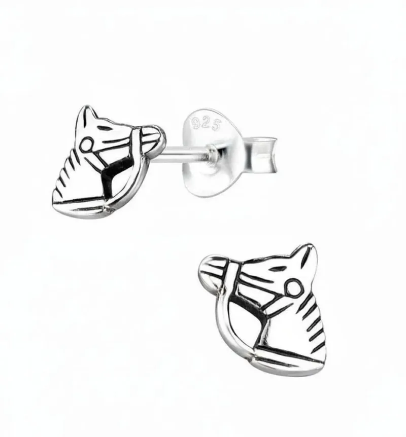 Örhänge med stift - Hästhuvud: Ett par silverfärgade hästhuvudformade örhängen med graverade detaljer, bridel och 925-stämpel för sterlingsilver samt fjärilsbakstycke.
