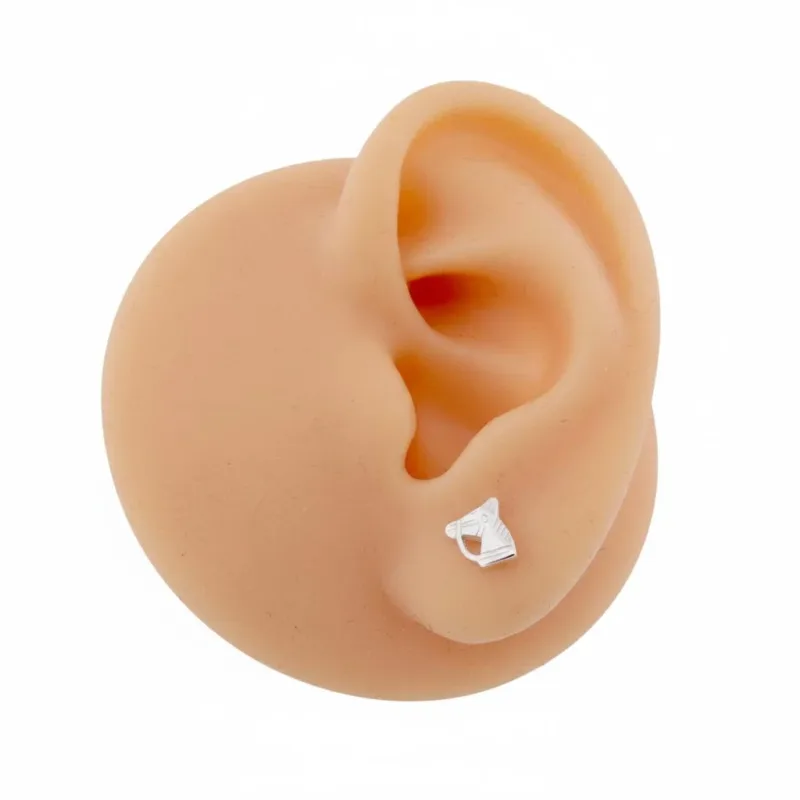 En realistisk silikonmodell av ett mänskligt öra visar "Örhänge med stift - Häst", ett litet silverfärgat hästformat örhänge, mot en vit bakgrund.