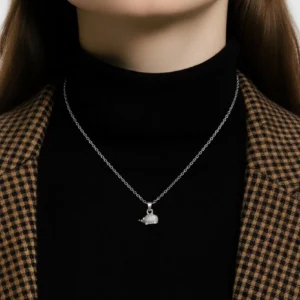 En kvinna klädd i svart polotröja och brunrutig kavaj visar upp ett Silverberlock Igelkott 14 mm halsband - endast den nedre halvan av hennes ansikte och hals syns.