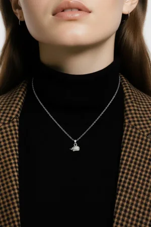 En kvinna klädd i svart polotröja och brunrutig kavaj visar upp ett Silverberlock Igelkott 14 mm halsband - endast den nedre halvan av hennes ansikte och hals syns.