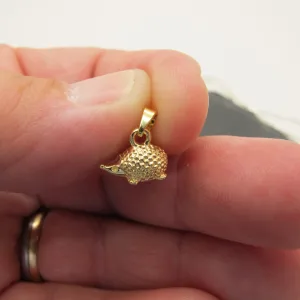 En hand håller i Silverberlock Igelkott 14mm berlock, med en texturerad yta som liknar igelkottspinnar och en liten ögla för att fästa på smycken.