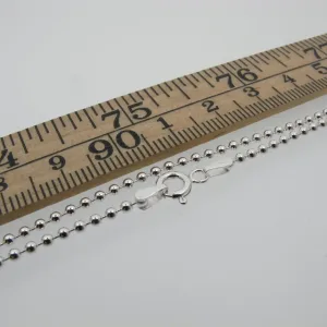 Kulkedja 2mm Halskedja 50-60cm silverkulhalsband med karbinlås visas bredvid en trälinjal märkt i centimeter och millimeter, vilket illustrerar dess ungefärliga längd på 50-60cm.