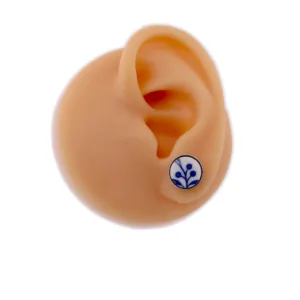 En realistisk öronmodell i silikon som visar Örhänge med stift - Dresden, ett runt vitt stiftörhänge med en enkel blå växtdesign.