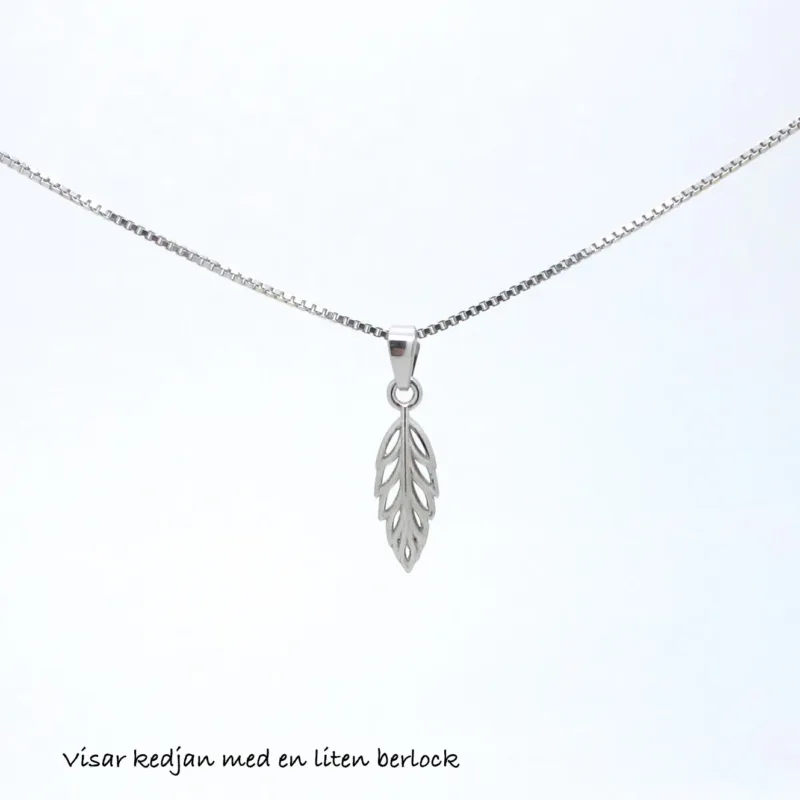 En fin Veneziakedja 0,8mm halskedja (42-45cm) med ett litet bladformat hänge visas mot en enfärgad vit bakgrund. Svensk text längst ned lyder, visar kedjan med en liten berlock.