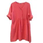 Linnetunika med fickor är en löst sittande, knälång korallrosa linneklänning med trekvartsärmar, V-ringning, knappar framtill och sidofickor, som visas på en vit bakgrund.