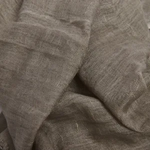 En närbild av Scarf i Linne & Viskos visar löst vävt, skrynkligt beige tyg med synlig struktur och naturliga veck.