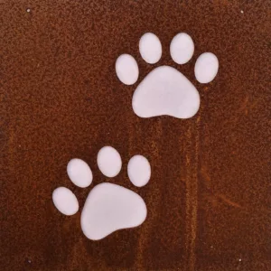 På den rostbruna metallplåten Hund dekorplåt för armeringsnät (14x14 cm) finns två vita tassavtryck, sannolikt av en hund.