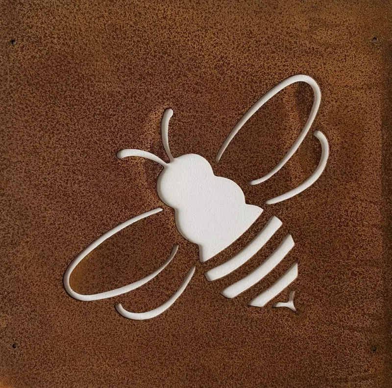 En rostfärgad metallskärning formad som en hund, "Hund dekorplåt för armeringsnät 14x14cm", avslöjar en vit bakgrund genom silhuetten. Designen har tydliga detaljer för en charmig dekorativ touch.