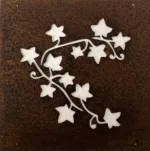 Ekorre dekorplåt för armeringsnät 14x14cm är en metallpanel med en rostbrun yta och utskurna murgröna blad och vinstockar, som avslöjar en ljusare bakgrund.