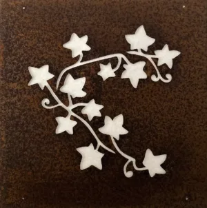 Ekorre dekorplåt för armeringsnät 14x14cm är en metallpanel med en rostbrun yta och utskurna murgröna blad och vinstockar, som avslöjar en ljusare bakgrund.