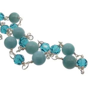 Amazonit rund ädelsten 6mm är en smyckesträng med runda ljusblå 6mm amazonitpärlor och fasetterade blågrönblå pärlor, alla sammanbundna med silvertrådsöglor.