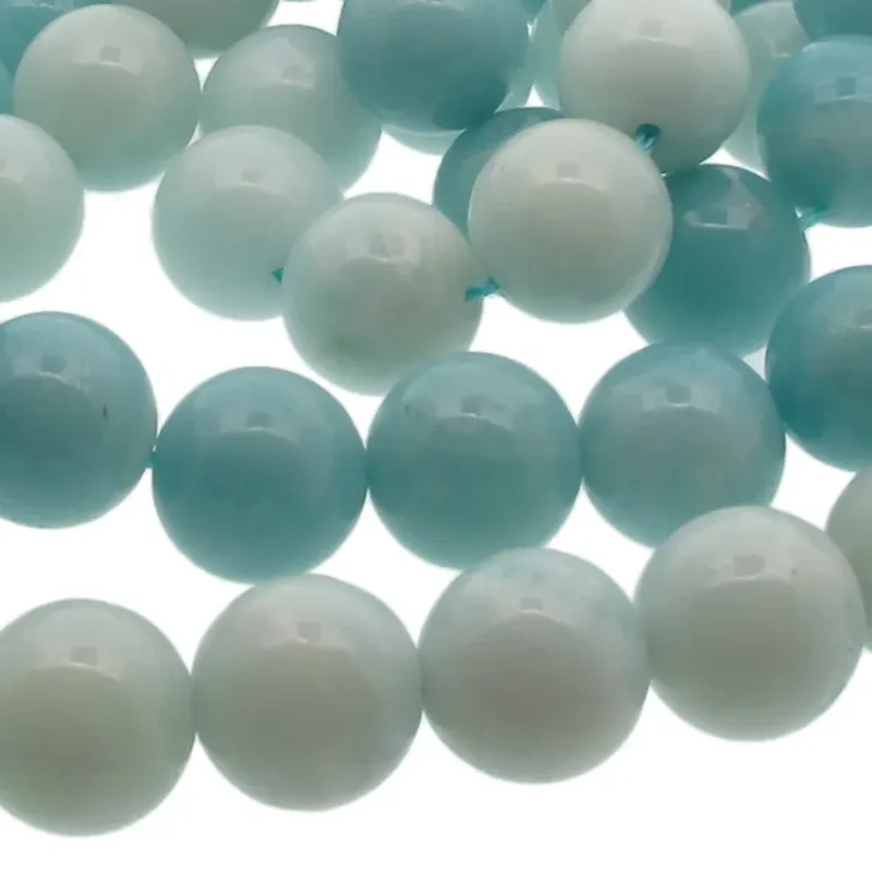 Närbild av Amazonit rund ädelsten 6mm pärlor i ljusblått och vitt med blank, polerad yta. De runda pärlorna är uppträdda med ett synligt blått snöre och arrangerade i ett lätt överlappande mönster.