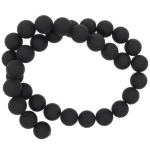 En sträng med Karneol rund ädelsten enfärg 4-6mm pärlor, arrangerade i en lös spiral mot en vit bakgrund.