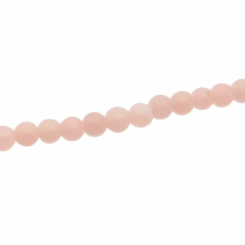 En sträng med Karneol rund ädelsten enfärg 4-6mm små, runda, ljusrosa pärlor visas diagonalt mot en vit bakgrund.