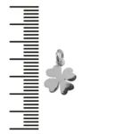 En liten, glänsande fyrklöverberlock med en ögla för fastsättning, placerad bredvid en svartvit måttskala för storleksreferens.