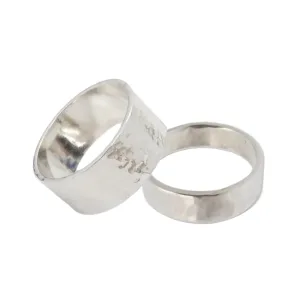 Två ringar "Fingerring hamrad yta i äkta silver" mot vit bakgrund - den ena bredare än den andra. Båda har en hamrad, strukturerad yta och en glänsande, reflekterande yta.