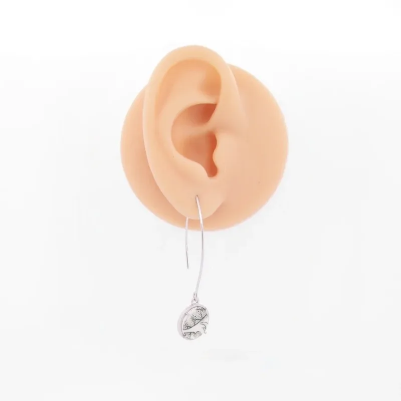 En realistisk öronmodell visar Öronkrok i Sterlingsilver Marquises, ett långt, tunt örhänge i sterlingsilver med ett litet, intrikat etsat runt hänge mot en slät vit bakgrund.