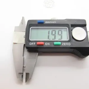 Ett digitalt skjutmått visar 1,99 mm på displayen när det mäter en Silverpärlor runda blanka 2mm/0,9mm pärla, med käftarna öppna och en linjal synlig i bakgrunden.