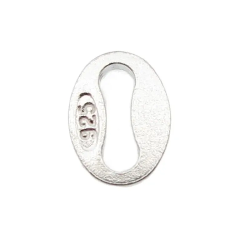 En liten, oval Hallmark kvalitetslänk ca 4x5mm smyckesbricka i silver med stämplat 925-märke, central utskärning och strukturerad yta.