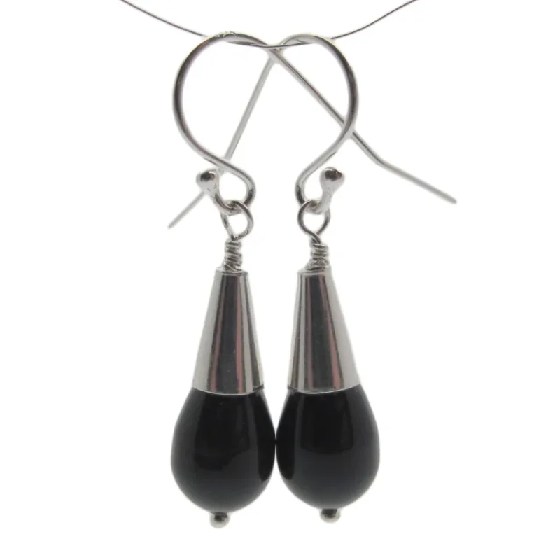 Ett par örhängen tillverkade med Hattpinne med kula 50mm/0,5mm, med svarta droppformade pärlor med silverfärgade lock och krokar, mot en vit bakgrund.