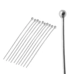Tio Hattpinne med kula 50mm/0,5mm är arrangerade i en solfjäderform mot en vit bakgrund. En huvudnål visas i närbild till höger, vilket framhäver dess rundade ände.
