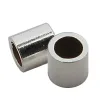 Två små, glänsande Krymphylsa sterlingsilver 2x2mm cylindriska metallpärlor med ihåliga centrum är placerade bredvid varandra på en vit bakgrund.