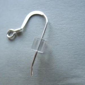 Enstaka silverörhänge i form av en fiskkrok med Silikonstopp för öronkrokar eller stift av genomskinligt gummi, på ljusgrå yta.