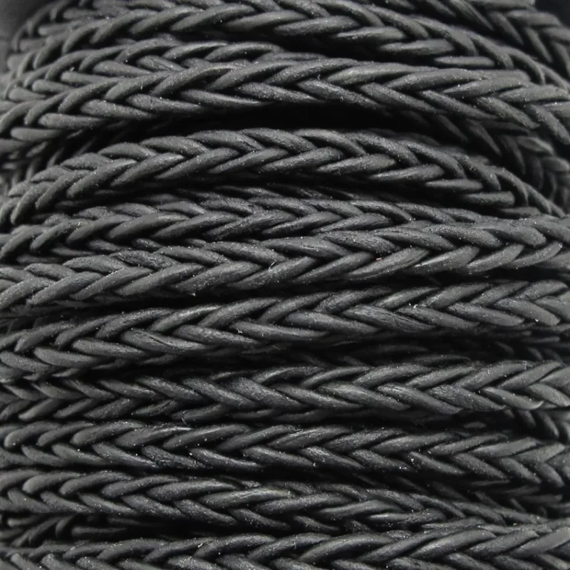 Närbild av flera tätt lindade Flätad fyrkantig läderrem Svart ca 4mm, som framhäver deras detaljerade vävda textur och mönster.