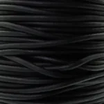 Närbild av flera Läderrem 3mm Matt-snören staplade i spiraler, vilket framhäver deras släta, matt svarta läderstruktur och subtila tjockleksvariationer.
