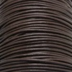 Närbild av flera tätt lindade Läderrem Brun 1,5-2 mm lädersnören staplade på varandra, vilket framhäver deras släta struktur och runda form.