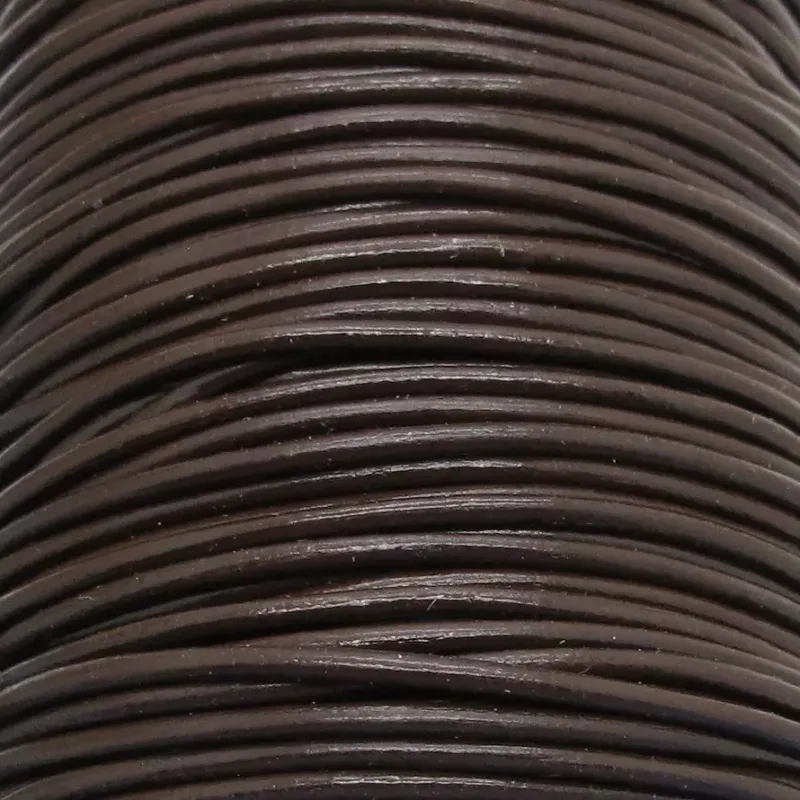 Närbild av flera tätt lindade Läderrem Brun 1,5-2 mm lädersnören staplade på varandra, vilket framhäver deras släta struktur och runda form.