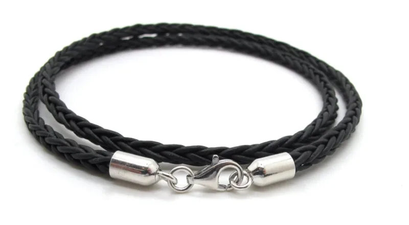 Ett svart flätat läderhalsband med Cylinderformat avslut för rem 5mm silverändar och ett kroklås, snyggt upprullat mot en vit bakgrund.