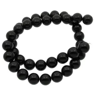 En tråd av glänsande svarta pärlor är lindad i en lös spiral mot en vit bakgrund.