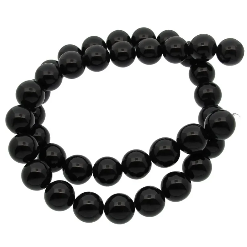 En tråd av glänsande svarta pärlor är lindad i en lös spiral mot en vit bakgrund.