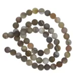 En sträng med runda, mattbruna agatpärlor med subtila vita och bruna ränder, arrangerade i en lös spiral mot en vit bakgrund.