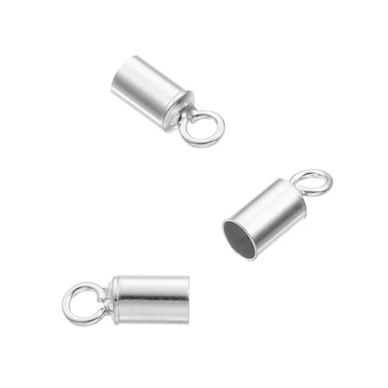 Tre Cylinderformad avslut för rem 3mm, små silverfärgade ändlock för metallsnoddar med öglor, är arrangerade mot en vit bakgrund. Varje cylindriskt lock har en öppen ände och en rund ögla för att fästa på smycken eller hantverk.