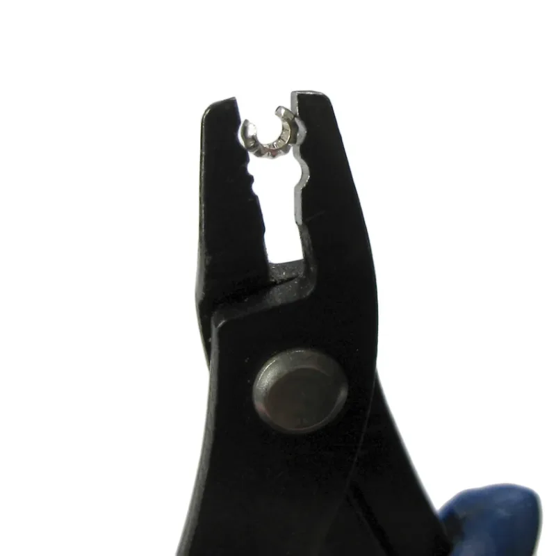 En Krympkåpa sterlingsilver 3mm visas mot en vit bakgrund, fasthållen av en svart tång med blått handtag.