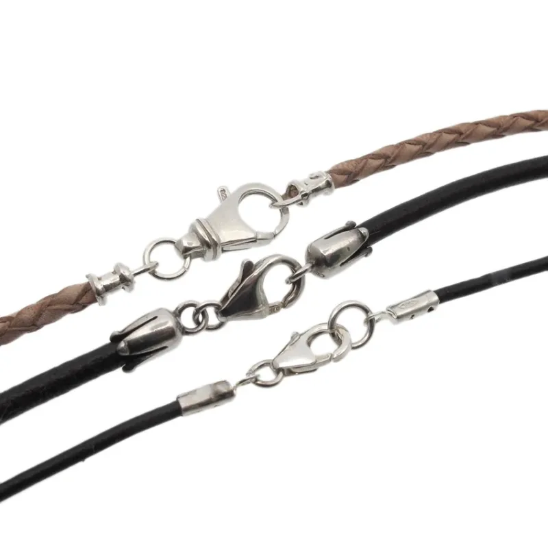 Tre Silverlås karbinhake-halsband - ett flätat brunt och två släta svarta - har karbinhakar i silver och ändstycken i metall, placerade sida vid sida på en vit bakgrund.