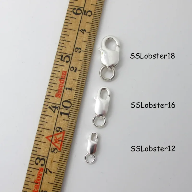 Tre Silverlås karbinhake avlång spännen (12mm, 16mm, 18mm) visas bredvid en centimeter linjal för skala.