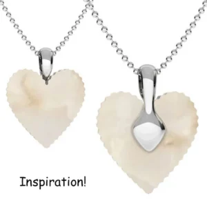 Två Spetsögla 16mm sterling silverhalsband med krämiga, marmorliknande hjärthängen visas sida vid sida mot en vit bakgrund. "Inspiration!" står skrivet under hängena.