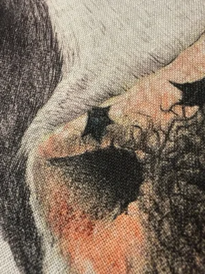 Närbild av "Kökshandduk med Kossan Rosa" visar en texturerad duk med ett detaljerat abstrakt mönster i svart, persika och rosa, föreställande en del av ett ansikte med ett öga och omgivande hud.