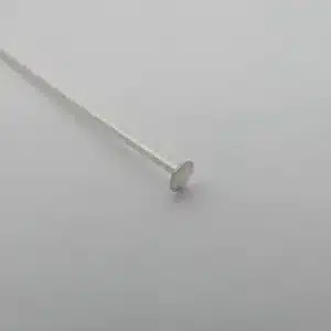 En Hattpinnar 25-50mm/0,51 huvudnål i sterlingsilver vilar på en slät, ljusgrå yta. Den har ett tunt, rakt skaft i sterlingsilver och ett platt, runt huvud - perfekt för smyckestillverkning.