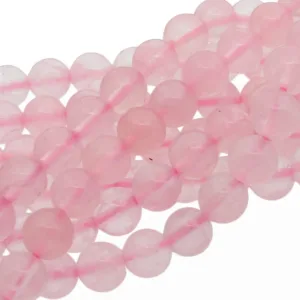 Närbild av flera trådar med runda, polerade rosa rosenkvartspärlor, arrangerade i lätt överlappande rader mot en vit bakgrund.