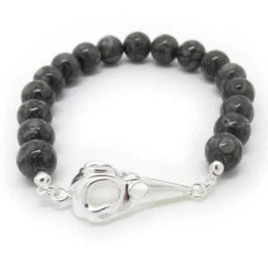 Knutgömma sterlingsilver 3mm armband med runda, mörkgrå pärlor och ett silverfärgat fågelskallespänne, på en vit bakgrund.