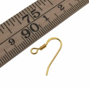 En Öronkrok förgylld med spiral 19mm visas bredvid en trälinjal, vilket indikerar att den guldfärgade örhängekroken mäter cirka 2 centimeter i längd.