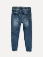 The Cozy elastisk byxa - Jeans är blå denimbyxor, visade bakifrån med två fickor och en elastisk linning, liggande platt på en vit bakgrund.